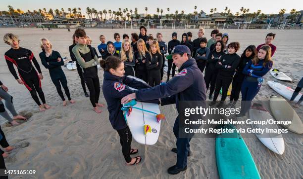 Huntington Beach, CA Kate Yasko, left, and Derek Peters of the Huntington Beach Marine Safety Division demonstrate how to rescue a person laying face...