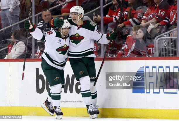 Matt Boldy of the Minnesota Wild celebrates his game winning goal with teammate Mats Zuccarello during the overtime period against the New Jersey...