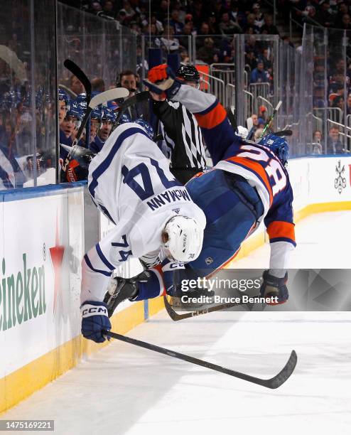 Alexander Romanov of the New York Islanders checks Bobby McMann of the Toronto Maple Leafs during the third period at the UBS Arena on March 21, 2023...