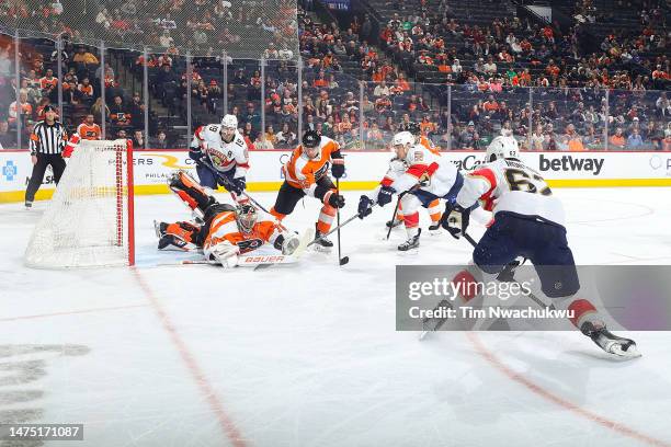 Carter Hart of the Philadelphia Flyers makes a save past Sam Reinhart of the Florida Panthers during the third period at Wells Fargo Center on March...