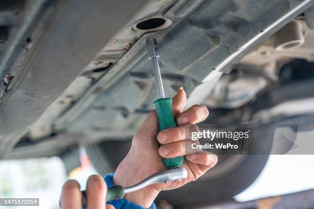 unscrew the screws on the chassis of the car - chassis stockfoto's en -beelden