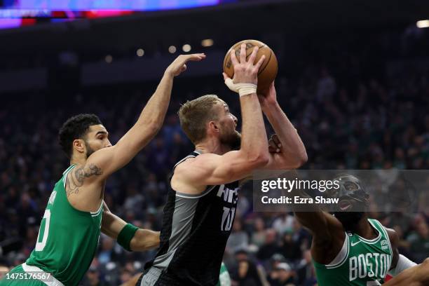 Domantas Sabonis of the Sacramento Kings goes up for a shot on Jayson Tatum and Jaylen Brown of the Boston Celtics in the first half at Golden 1...