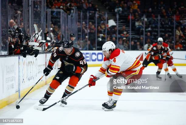Max Jones of the Anaheim Ducks skates the puck against Rasmus Andersson of the Calgary Flames in the second period at Honda Center on March 21, 2023...