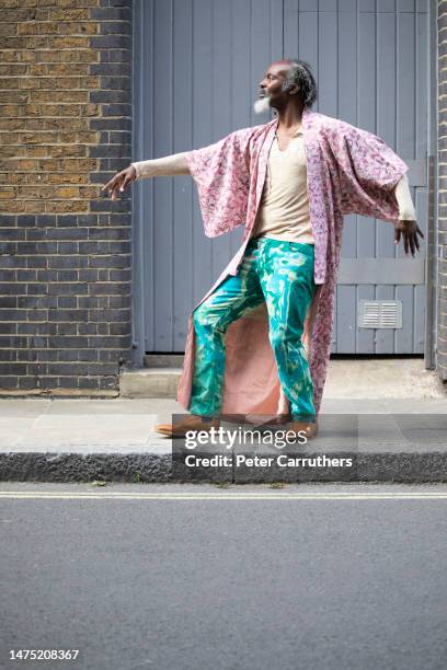 unconventional mature man dancing in the street by a warehouse doorway - pink pants stock pictures, royalty-free photos & images