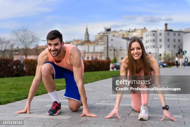 若いカップルが公園で走る準備をしています。 - professional sportsperson ストックフォトと画像