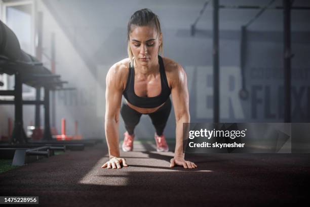 athletic woman exercising push-ups in a health club. - bodyweight training stock pictures, royalty-free photos & images