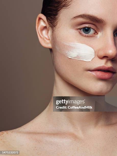 girl inflicting cream - pretty eye makeup for blue eyes stock pictures, royalty-free photos & images