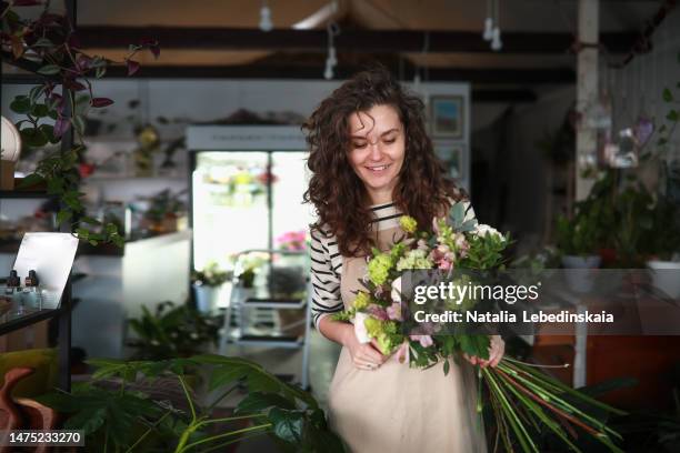 smiling gardener. portrait of florist working in her shop - fiorista foto e immagini stock