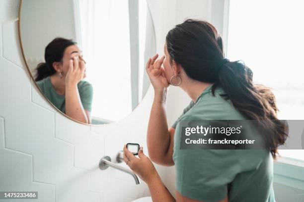 woman using make up in the bathroom - woman make up face wipes not men stock pictures, royalty-free photos & images