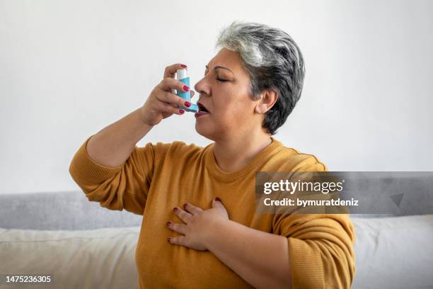 frau, die asthma einatmet - asthmatic stock-fotos und bilder