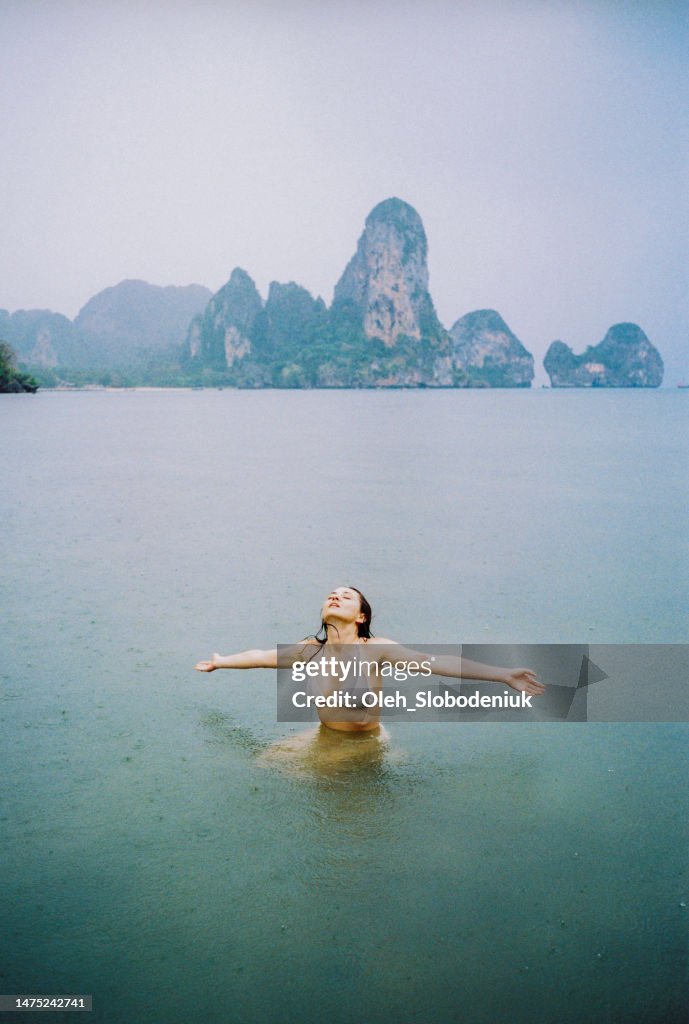 Woman swimming in the sea under the rain