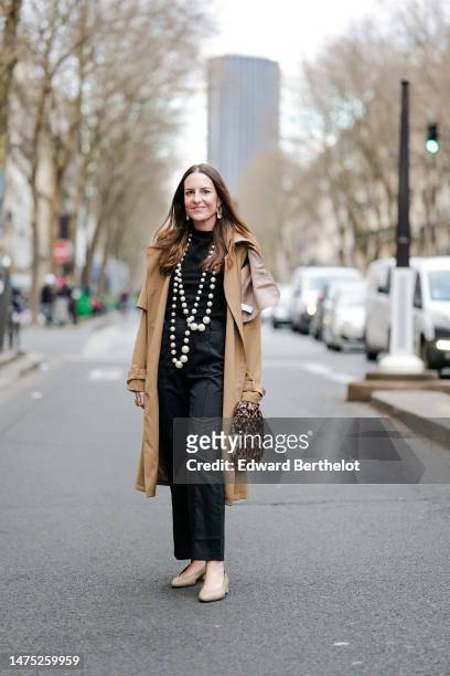 Alba Garavito Torre wears long earrings, a long beaded pearl necklace, a black knit short sleeve sweater with a round neckline from Zara, black high...