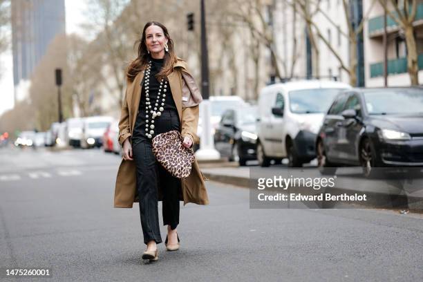 Alba Garavito Torre wears long earrings, a long beaded pearl necklace, a black knit short sleeve sweater with a round neckline from Zara, black high...