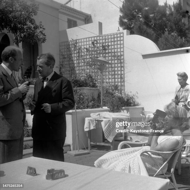 Robert Lamoureux et Jacqueline Pagnol sur la terrasse d'un restaurant à Cannes, en mai 1957.