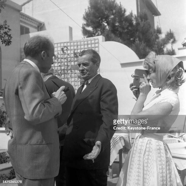 Robert Lamoureux et Jacqueline Pagnol sur la terrasse d'un restaurant à Cannes, en mai 1957.