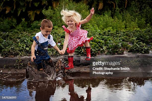 boy and girl holding hand - kids mud stock pictures, royalty-free photos & images