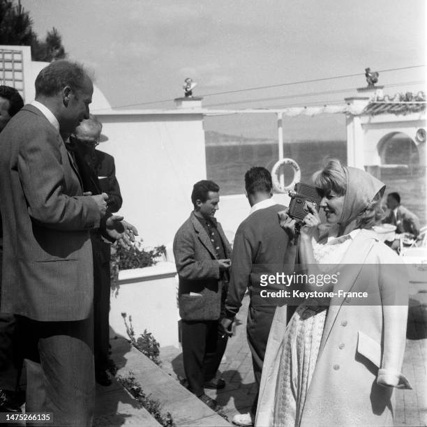Robert Lamoureux et Jacqueline Pagnol sur la terrasse d'un restaurant à Cannes, en mai 1957.