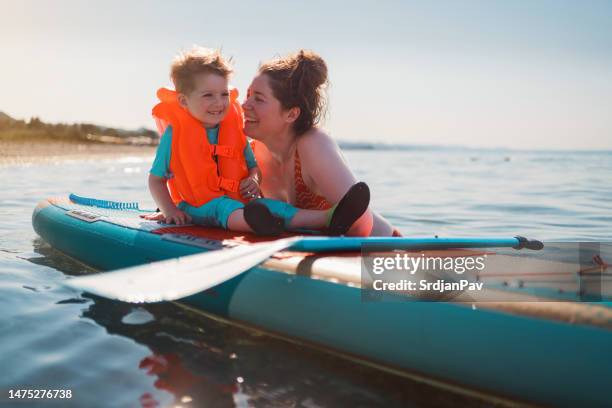 mother and son on a paddleboard - sup stockfoto's en -beelden