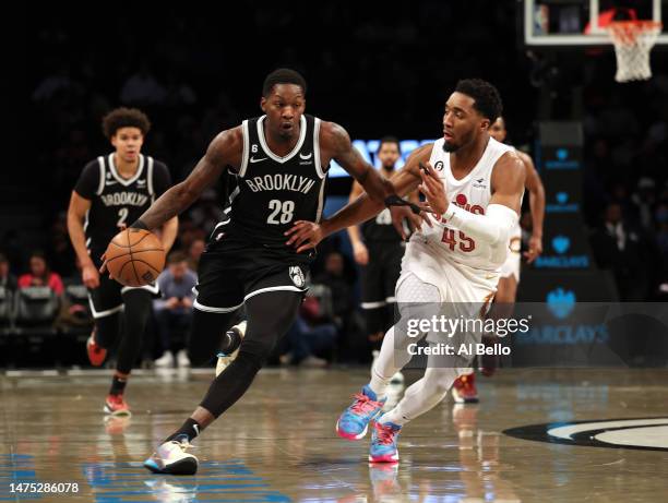 Dorian Finney-Smith of the Brooklyn Nets dribbles against Donovan Mitchell of the Cleveland Cavaliers during their game at Barclays Center on March...