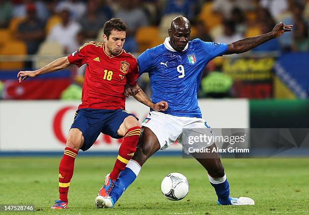 Jordi Alba of Spain and Mario Balotelli of Italy tussle for the ball during the UEFA EURO 2012 final match between Spain and Italy at the Olympic...