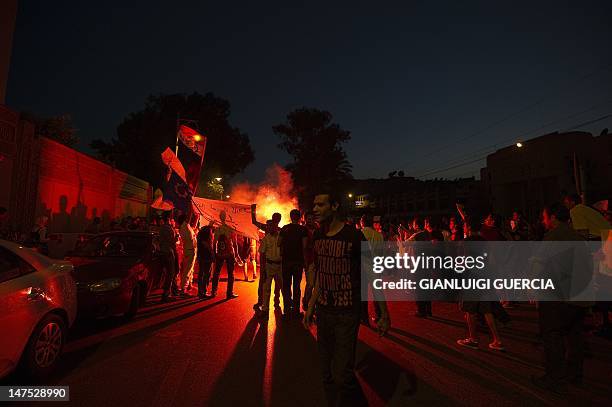 Protesters light flares as hundreds demonstrate on July 1, 2012 in front of the presidential palace in Cairo to demand the realease of political...