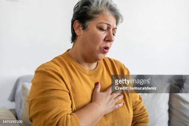 woman hand holding chest pain, difficulty to breathe - tossir imagens e fotografias de stock