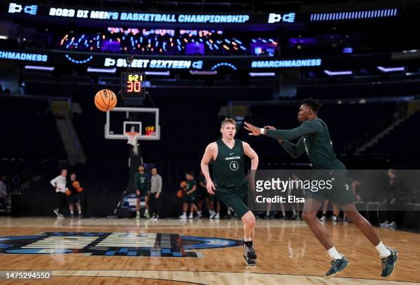 Mady Sissoko of the Michigan State Spartans passes the ball as Jaxon Kohler runs by during a practice session for the NCAA Men's East Regional at...