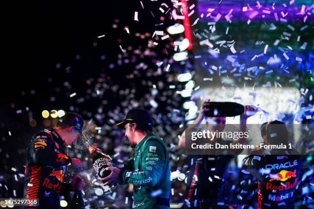 Third placed Fernando Alonso of Spain and Aston Martin F1 Team celebrates on the podium with Second placed Max Verstappen of the Netherlands and...