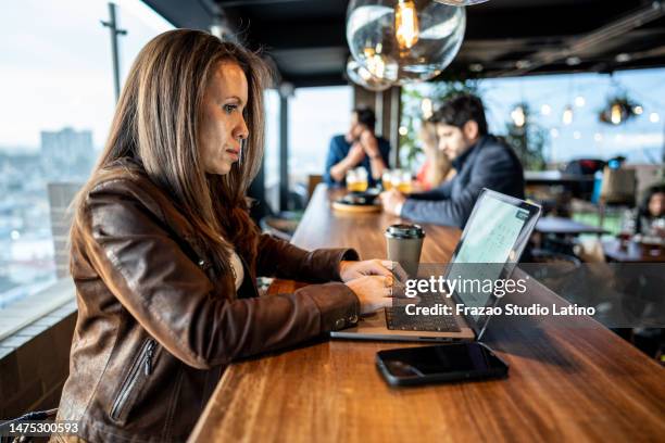 mature woman using laptop in the restaurant on the rooftop - busy pub stock pictures, royalty-free photos & images
