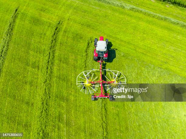 tracteur tirant un râteau rotatif pour ramasser le foin d’une prairie d’herbe vue d’en haut - dutch culture stock photos et images de collection