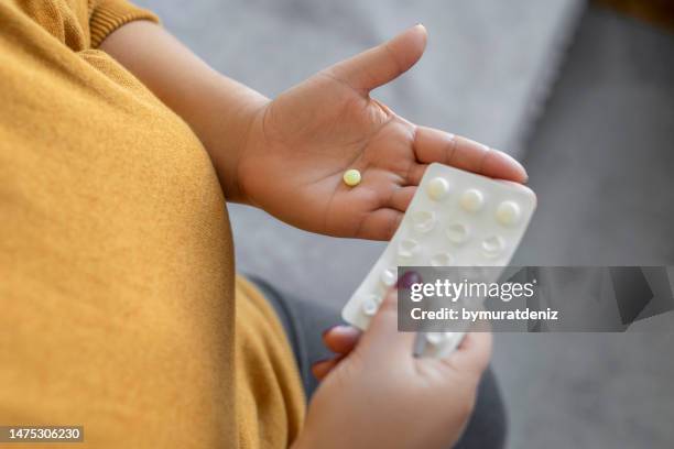 mujer agarrando pastillas - medicamento para la alergia fotografías e imágenes de stock
