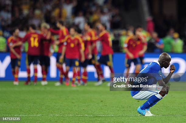 Mario Balotelli of Italy shows his dejection as the the Spanish team celebrate after Juan Mata of Spain scored their fourth goal during the UEFA EURO...