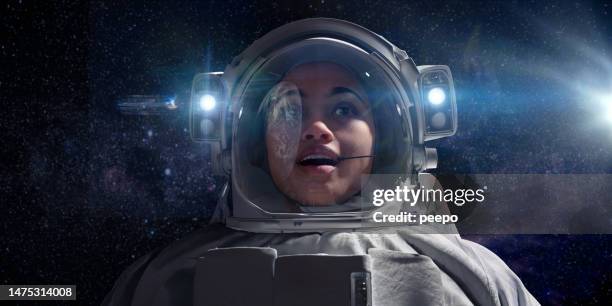 astronautin, die die erde aus dem weltraum betrachtet - astronaut potrait stock-fotos und bilder