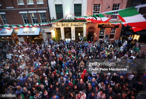 Italian football supporters stand outside Bar Italia to watch the screening of the UEFA EURO 2012 final football match between Spain and Italy,...