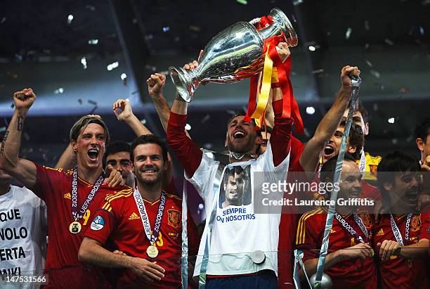 Sergio Ramos of Spain lifts the trophy next to team-mates Fernando Torres, Juan Mata, Andres Iniesta and David Silva as they celebrates following...