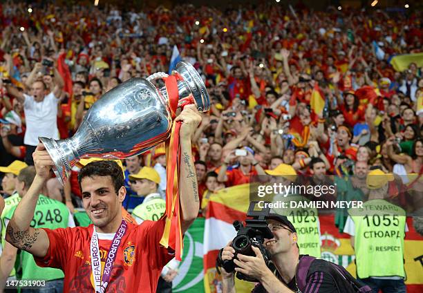 Spanish midfielder Cesc Fabregas holds the trophy after winning the Euro 2012 football championships final match Spain vs Italy on July 1, 2012 at...