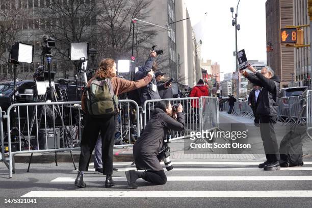 Journalists photograph a demonstrator protesting outside of the Criminal Courts Building as the grand jury continues to hear evidence against former...
