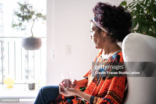 senior woman looking away contemplating at home - low self esteem stock pictures, royalty-free photos & images