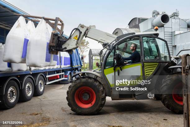 farmer receiving  a delivery of nitrogen sulphur fertiliser to a sustainable farm. - fertiliser stock pictures, royalty-free photos & images