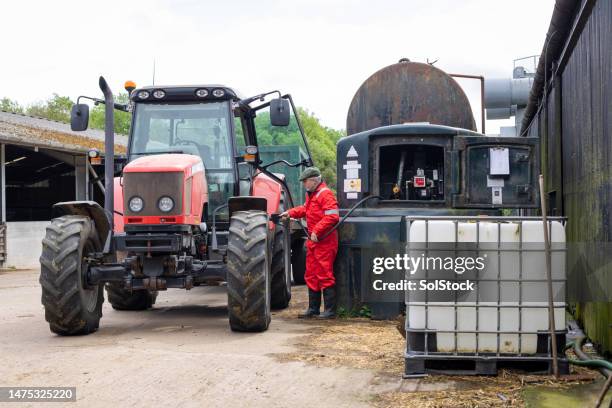 den landwirtschaftlichen traktor auf seinem hof betanken - tractor filling up with fuel stock-fotos und bilder