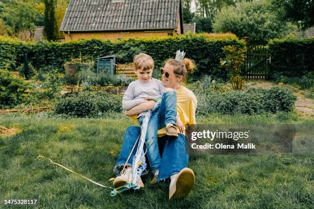 mother and son celebrating birthday outdoors in nature. summer garden party - family moments stock-fotos und bilder
