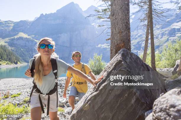 deux personnes randonnant dans un magnifique paysage alpin en été marchant dans les alpes suisses en profitant de la nature et du plein air - lac-oeschinensee photos et images de collection