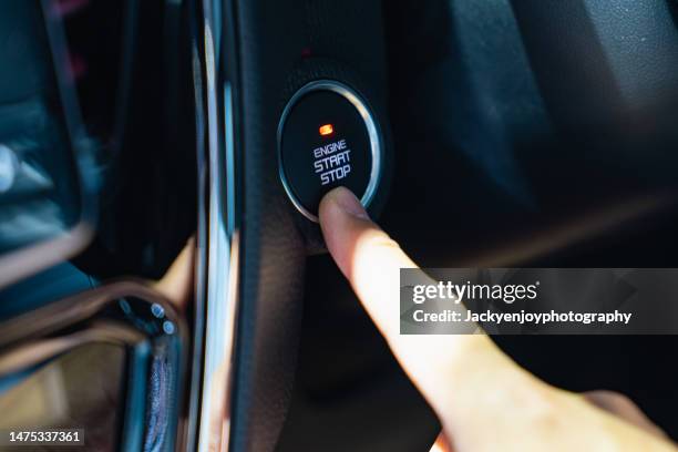 close-up of a hand reaching for the car's engine start button - turning key stock pictures, royalty-free photos & images