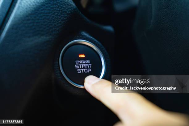 close-up of a hand reaching for the car's engine start button - car keys hand foto e immagini stock