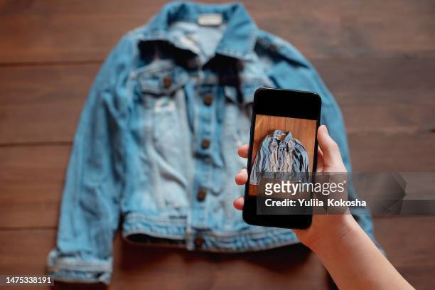 woman taking photo of denim shirt on smartphone - vêtement photos et images de collection