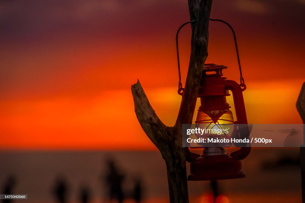 Close-up of illuminated lantern against sky during sunset