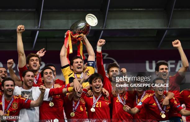 Spanish goalkeeper Iker Casillas holds the trophy as he celebrates with teammates after winning the Euro 2012 football championships final match...