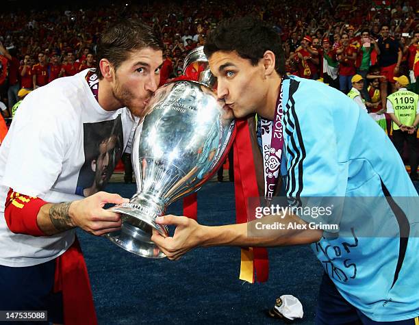 Sergio Ramos and Jesus Navas of Spain kiss the trophy following victory in the UEFA EURO 2012 final match between Spain and Italy at the Olympic...