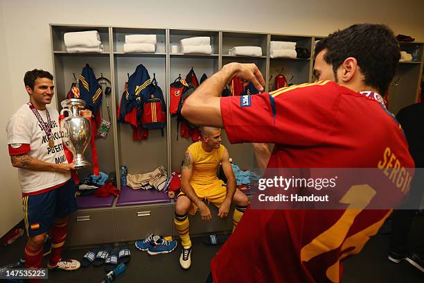 Cesc Fabregas of Spain poses in the dressing room with the trophy following the UEFA EURO 2012 final match between Spain and Italy at the Olympic...