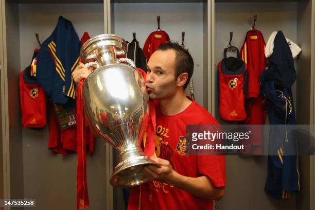 Andres Iniesta of Spain poses in the dressing room with the trophy following the UEFA EURO 2012 final match between Spain and Italy at the Olympic...